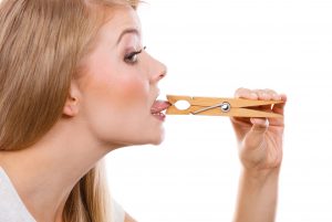 Blonde woman having tongue in clothespin